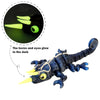 A dark blue chameleon fidget toy with glowing yellow horns and eyes, showing its glow in the dark feature.