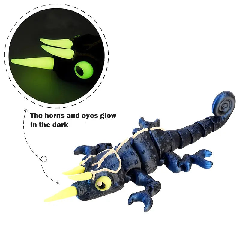 A dark blue chameleon fidget toy with glowing yellow horns and eyes, showing its glow in the dark feature.