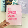 A pink A5 binder for a 100 envelope savings challenge with numbered pockets is held in a hand.