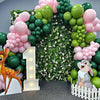 A balloon arch decoration featuring green and pink latex balloons with a deer figure and a rabbit figure.