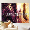 A framed poster featuring a My Chemical Romance theme with a cat sitting in front of it.