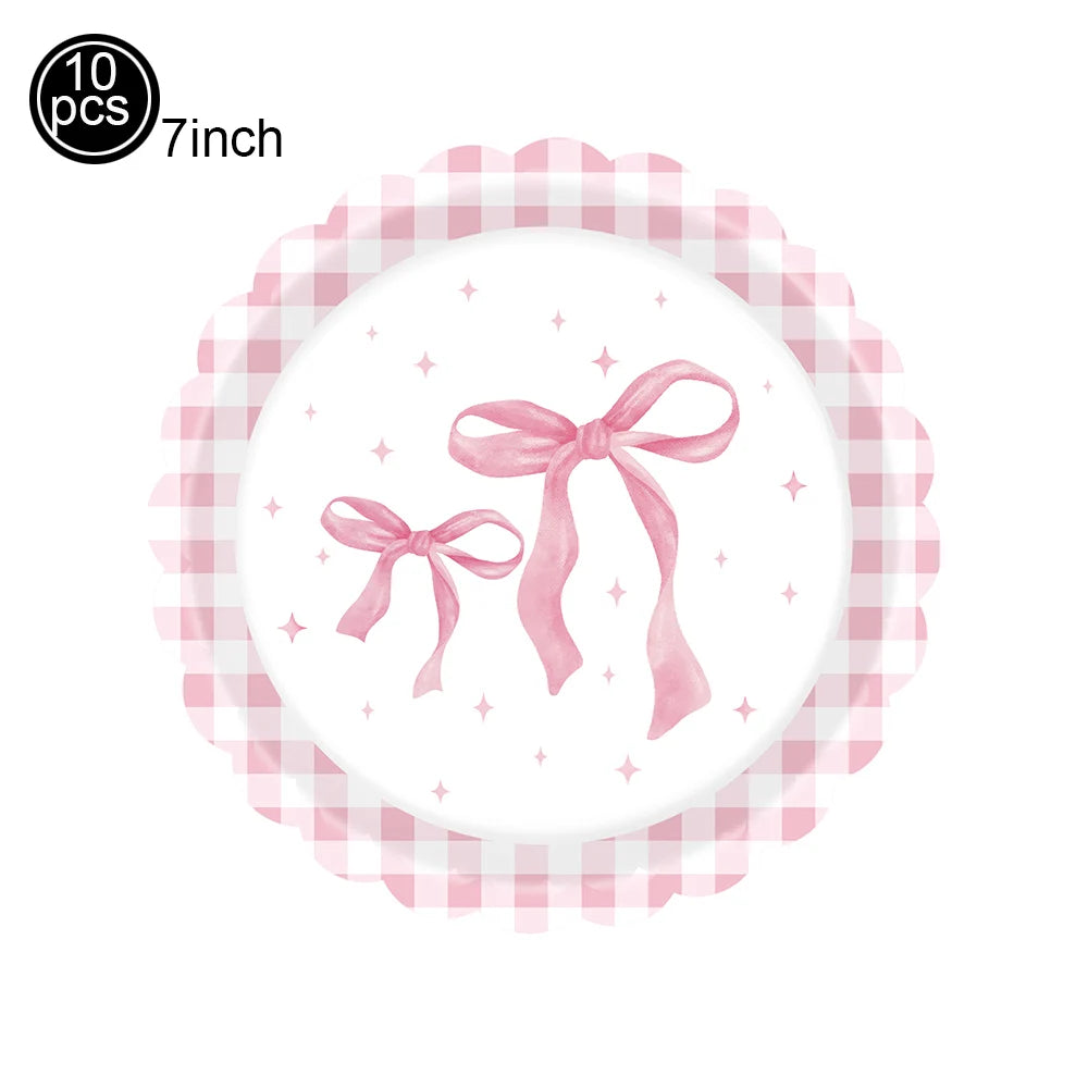 A white plate decorated with a pink bow illustration on a pink gingham plate.