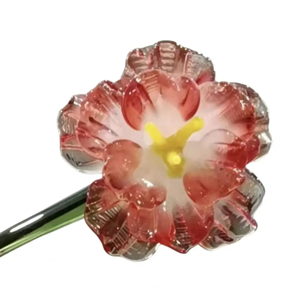 Handcrafted blue glass flower sculpture with pink petals and yellow center