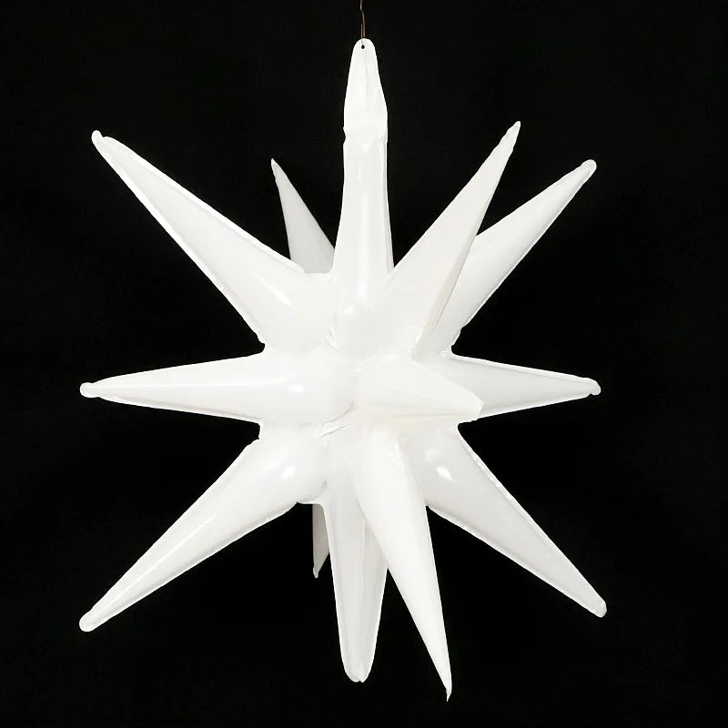 A white star burst foil balloon with sharp points, suspended against a black background.