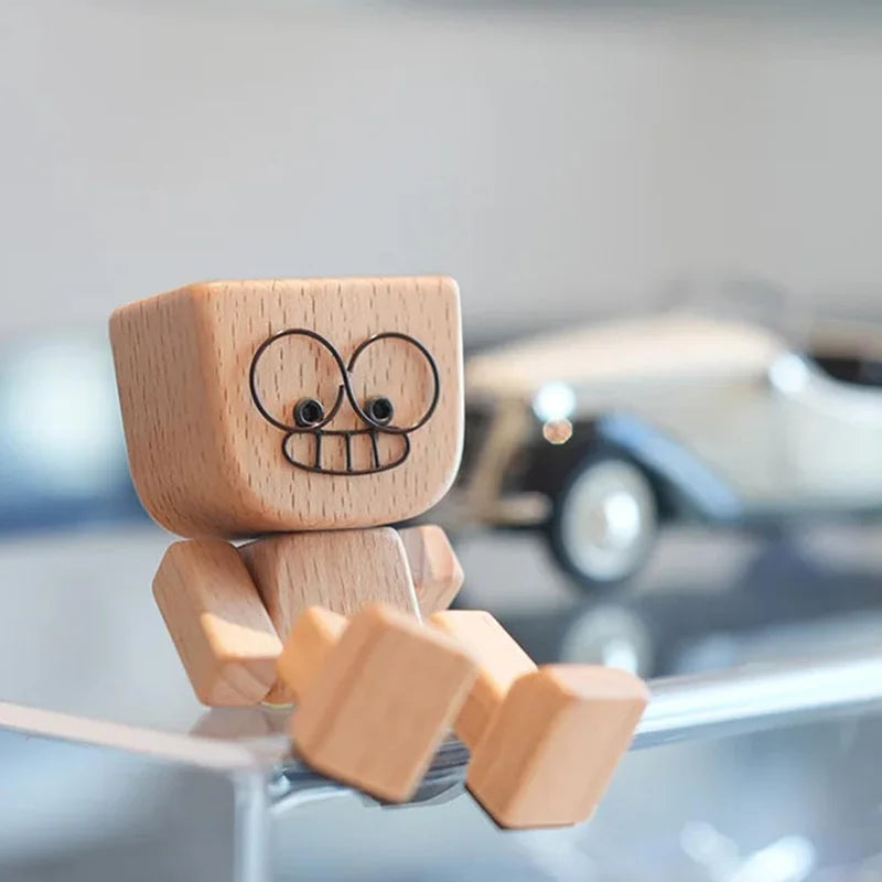 A small wooden figurine of a man with a smiling face and a car, sitting on a glass surface.