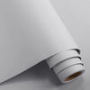 Roll of matte peel and stick decor stickers on a light gray surface.