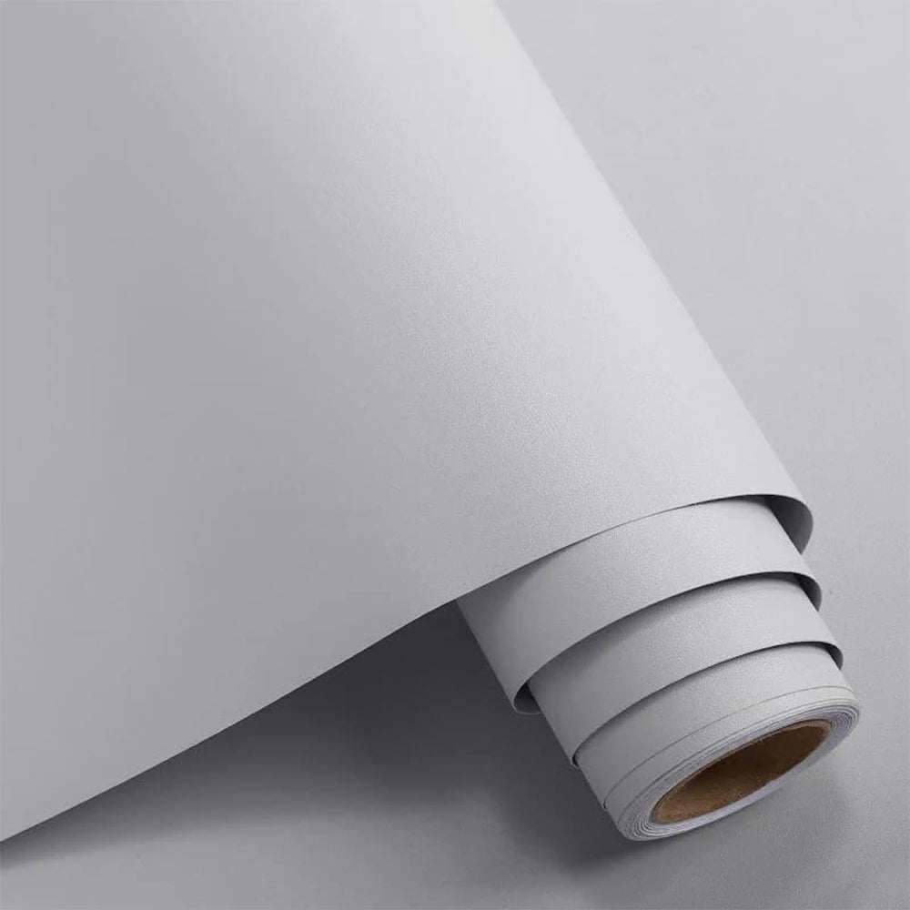 Roll of matte peel and stick decor stickers on a light gray surface.
