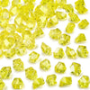 Yellow decorative crushed diamond acrylic pebbles scattered on a white background