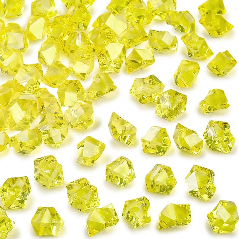 Yellow decorative crushed diamond acrylic pebbles scattered on a white background