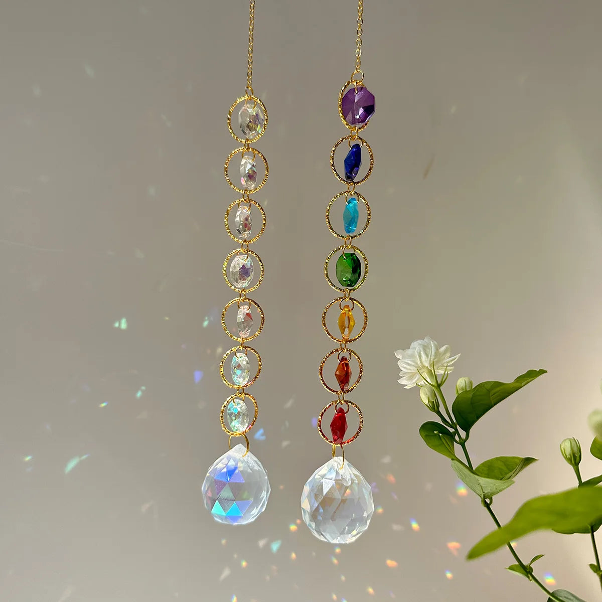 A pair of long, delicate gold-toned earrings featuring various colored crystal prisms and faceted stones.