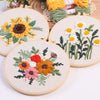 Punch needle embroidery kit featuring floral designs on stamped cloth with tools and yarn