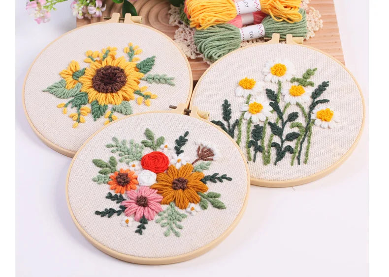 Punch needle embroidery kit featuring floral designs on stamped cloth with tools and yarn