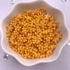 A bowl filled with yellow 3D resin flower gems for crafts and DIY projects