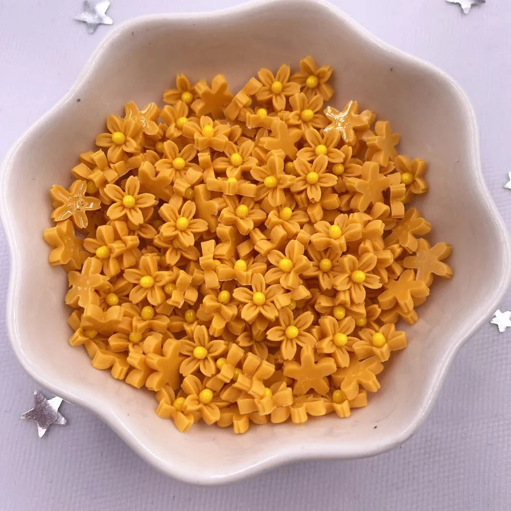 A bowl filled with yellow 3D resin flower gems for crafts and DIY projects