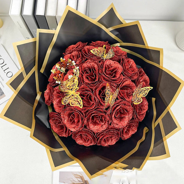 A bouquet of deep red glitter roses arranged in a dark wrapper with gold accents.