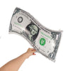 A hand holds a rolled US one dollar bill, used as casino dice foil balloons for party decor.