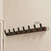 A walnut wood coat rack with eight hooks mounted on a shelf for coat storage.