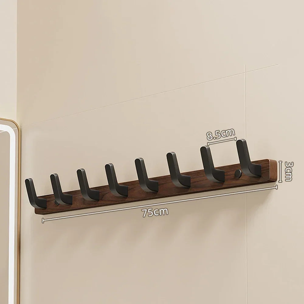 A walnut wood coat rack with eight hooks mounted on a shelf for coat storage.