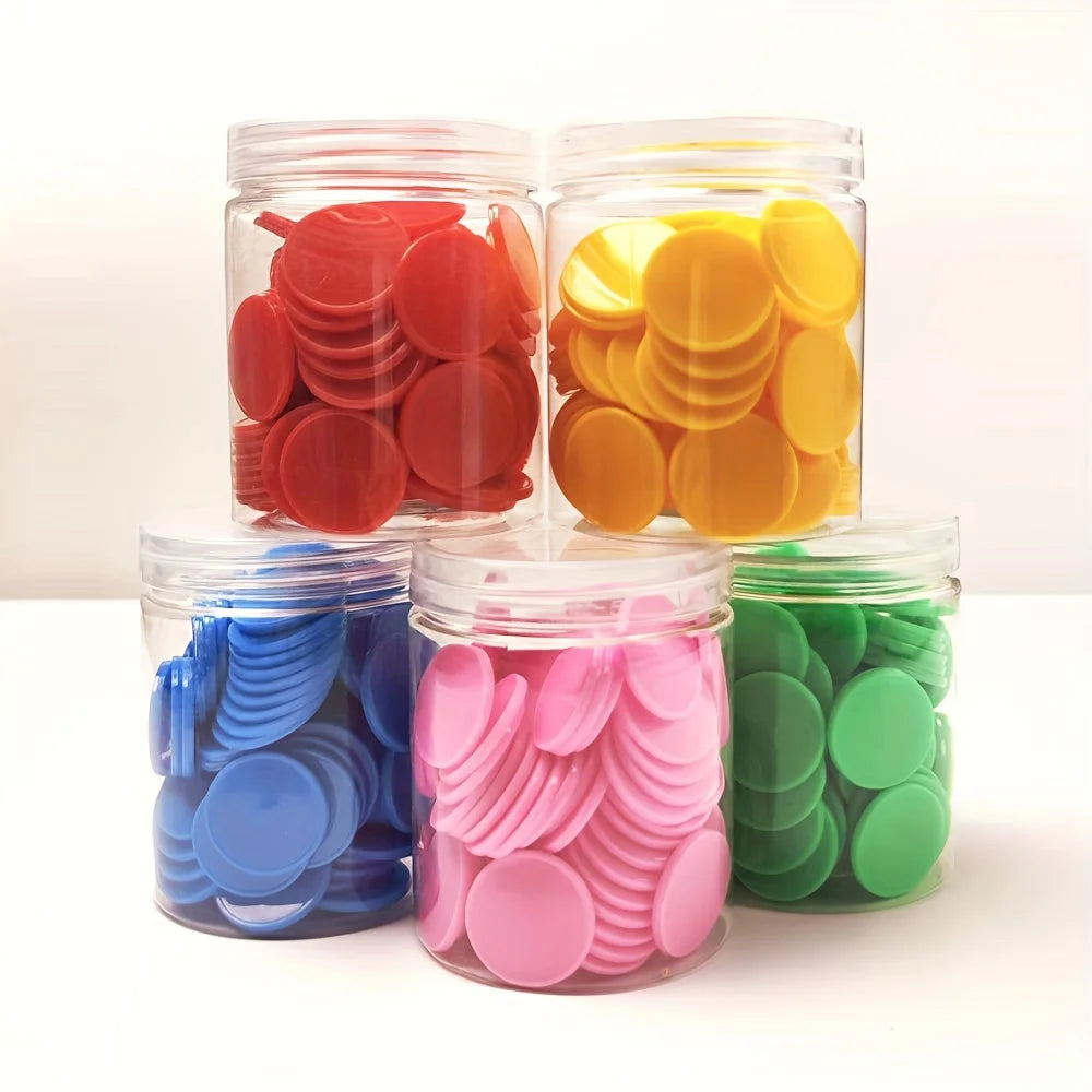 Three glass jars filled with colorful plastic counting chips in red, yellow, and green.