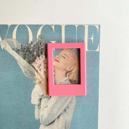 A pink rectangular photo frame with a woman's face inside, set against a teal background.