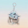 A light blue acrylic keychain shaped like a cat face with an open mouth and teeth, featuring Chinese characters.
