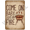 A distressed metal sign with text that reads Come On Baby Light My Fire and features a silhouette of a grill.