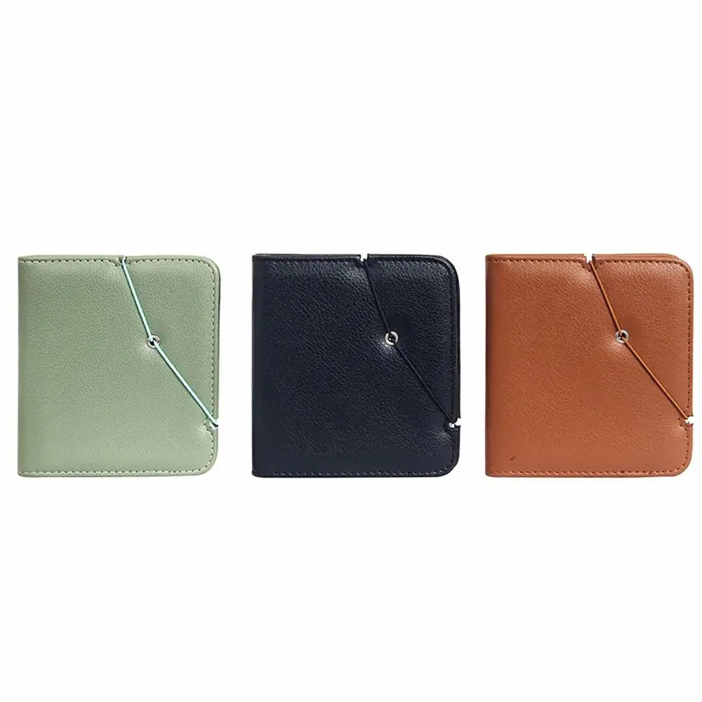 Three leather photo albums in sage green, navy blue, and tan brown.