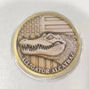 A round collectible coin featuring an alligator head against a background of American flag stripes and stars.