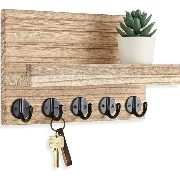 A wooden wall key holder with a shelf displaying several black and brass keys.