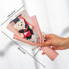 A handcrafted crochet flower bouquet featuring a teddy bear in a pink paper wrapping.