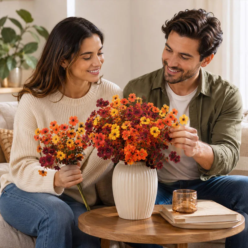 A woman and man smiling while holding a bouquet of vibrant artificial pansy flowers on a wooden table.