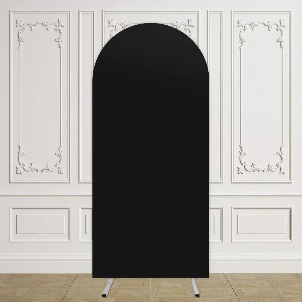 Un arco de fondo de tela negra oval y alta, exhibido contra una pared blanca con molduras decorativas.