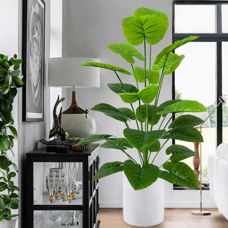 A large, lush artificial tree with vibrant green leaves in a white pot displayed indoors.