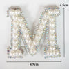 A large letter M made of white pearls and rhinestones, used as an alphabet letter rhinestone patch for clothing.