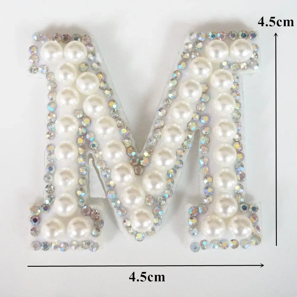 A large letter M made of white pearls and rhinestones, used as an alphabet letter rhinestone patch for clothing.