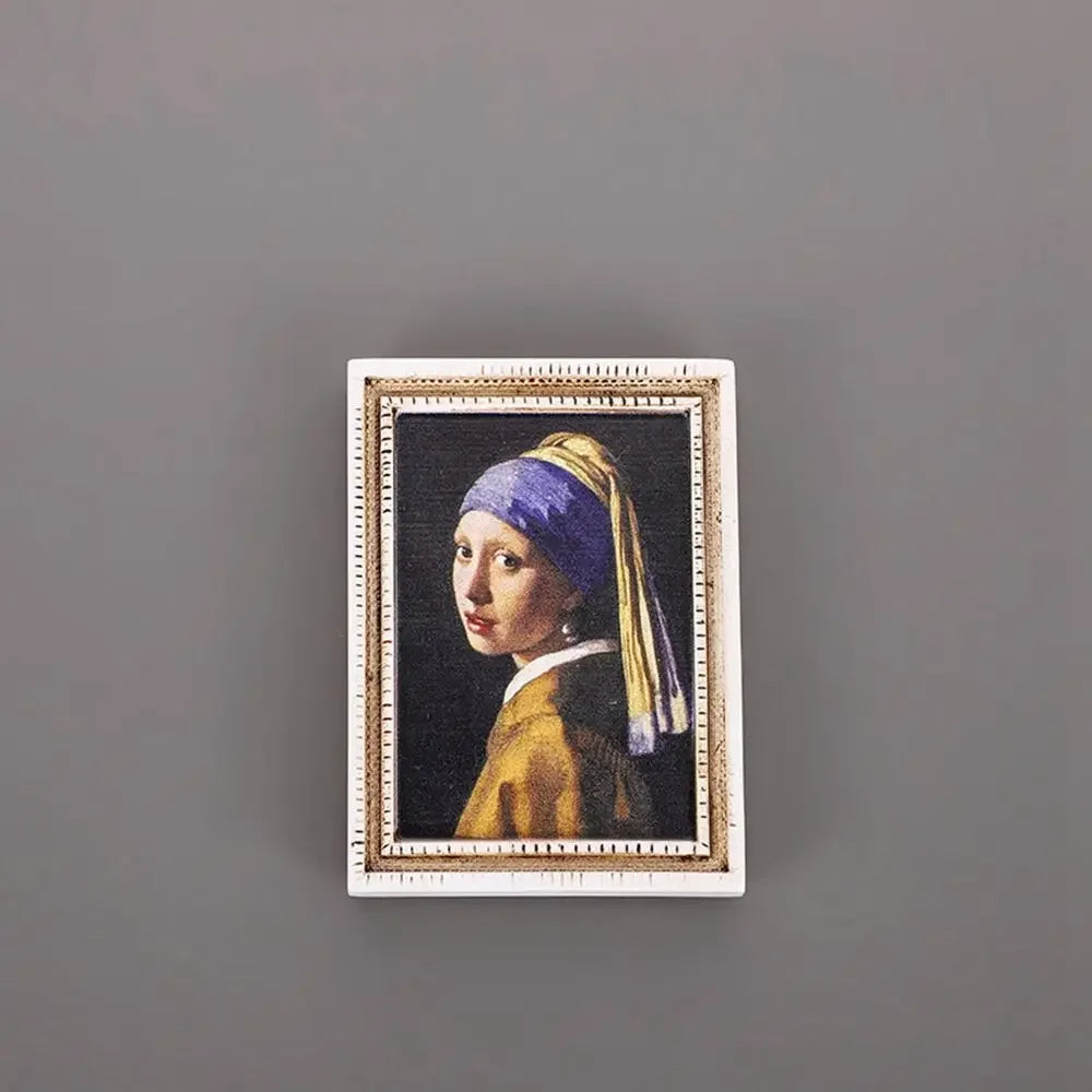 A framed painting featuring a woman wearing a purple and yellow headscarf against a dark background.