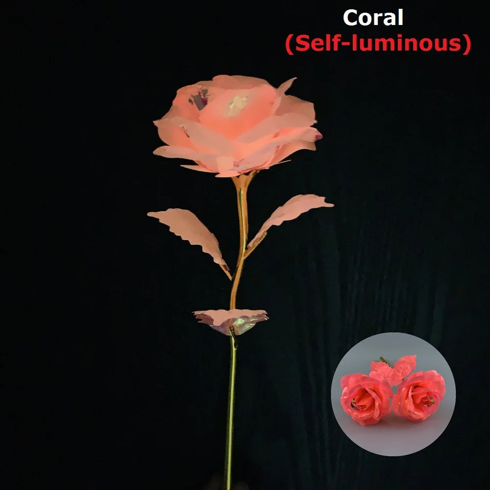 A pink coral self-luminous rose with gold foil petals against a dark background.