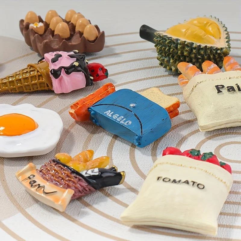 A collection of colorful 3D resin food magnets featuring various fruits and vegetables like pineapple, carrots, and other pro