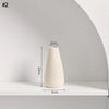 A tall, tapered beige ceramic vase displayed on a white shelf.