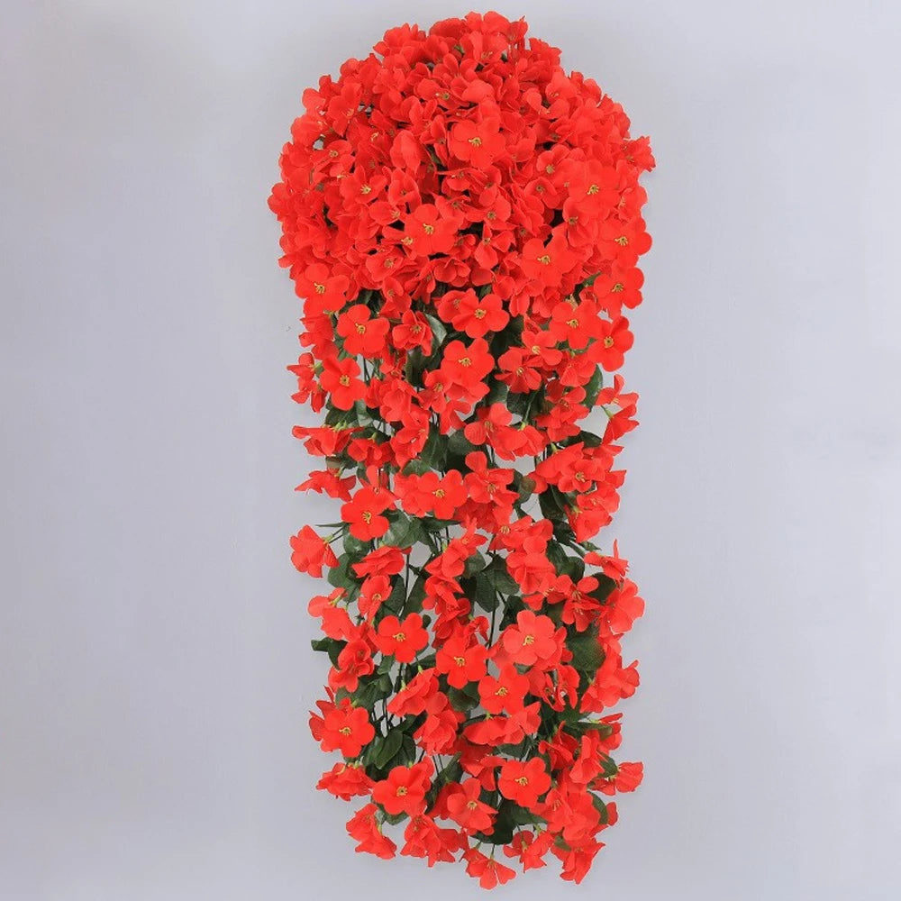 A dense hanging garland made of bright orange-red artificial flowers for wedding and home decor