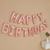 A banner of pink foil letter balloons spelling out Happy Birthday for party decoration.