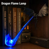 A blue dragon flame lamp with a bat-like wing design rests on a stack of books.