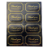 A sheet of thank you seal stickers for crafting and packaging featuring repeated text on gold-colored labels.