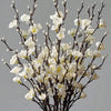 Branch of artificial plum blossoms with white flowers and dark branches