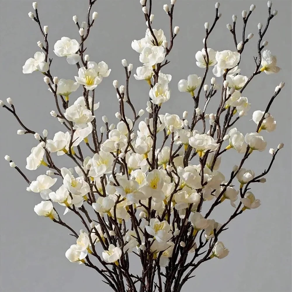 Branch of artificial plum blossoms with white flowers and dark branches