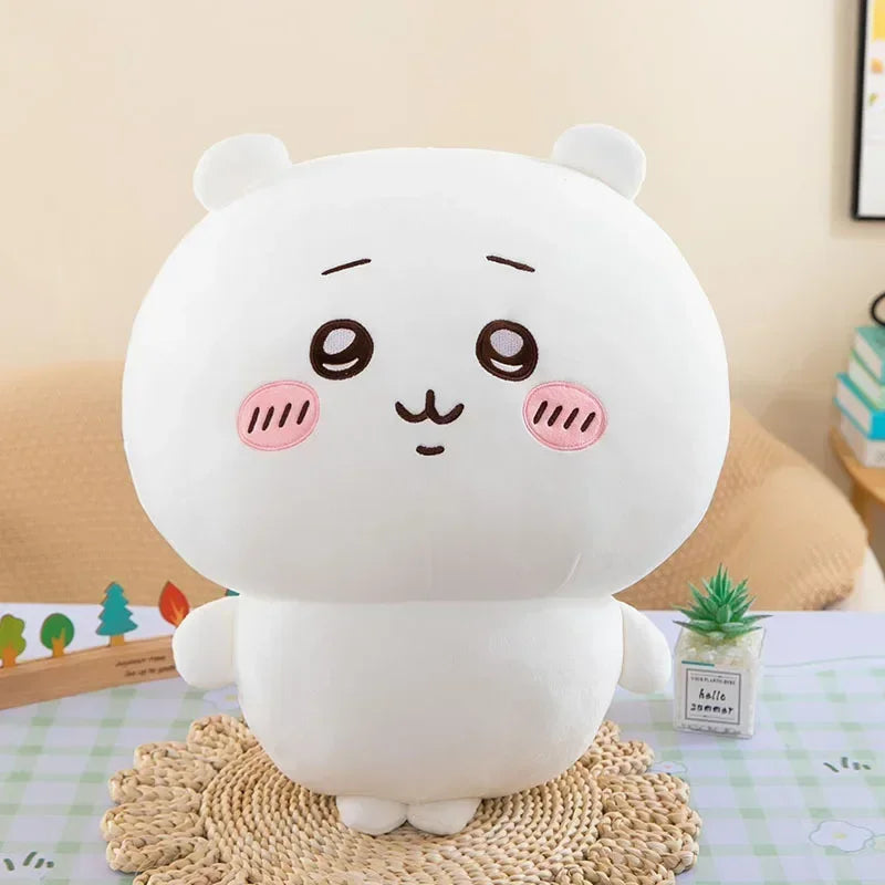 A white Usagi Chiikawa plush doll with pink accents sitting on a woven mat.