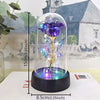 A glass dome featuring a purple rose with glowing LED light, displayed on a black base.