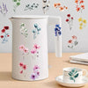 A white water bottle featuring delicate watercolor floral decals in shades of pink, purple, and blue.