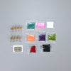 A collection of various colored glitter powders in small plastic packets for party decorations.