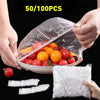 Hands are holding a clear plastic bag filled with fresh tomatoes and other produce, demonstrating reusable elastic food cover